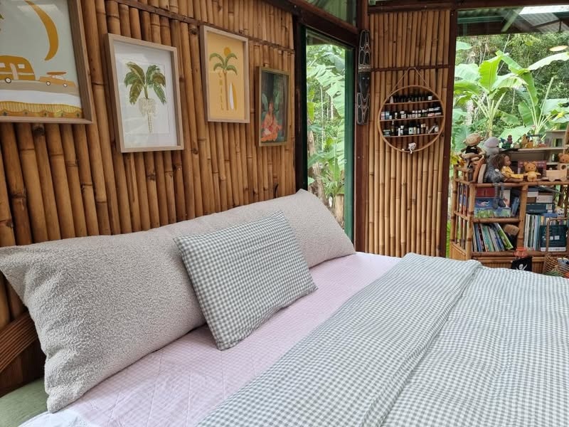 Bouclé cushion against bamboo wall with tropical garden view