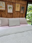 Ecru bouclé bedhead cushion with bamboo decor and tropical plants