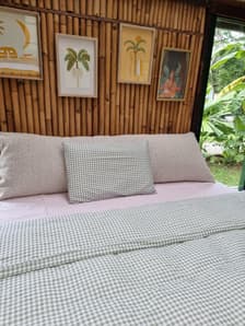 Ecru bouclé bedhead cushion with bamboo decor and tropical plants