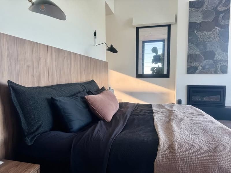Black bouclé bedhead cushion styled on white linen bedding