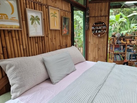 Bouclé cushion against bamboo wall with tropical garden view