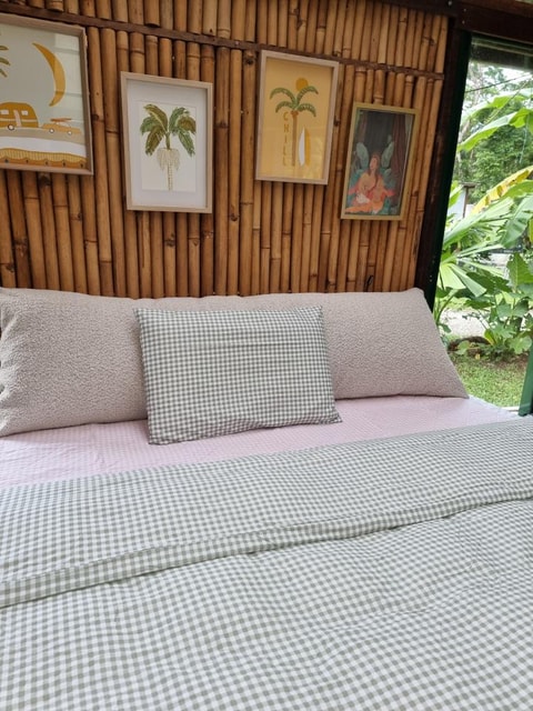 Ecru bouclé bedhead cushion with bamboo decor and tropical plants